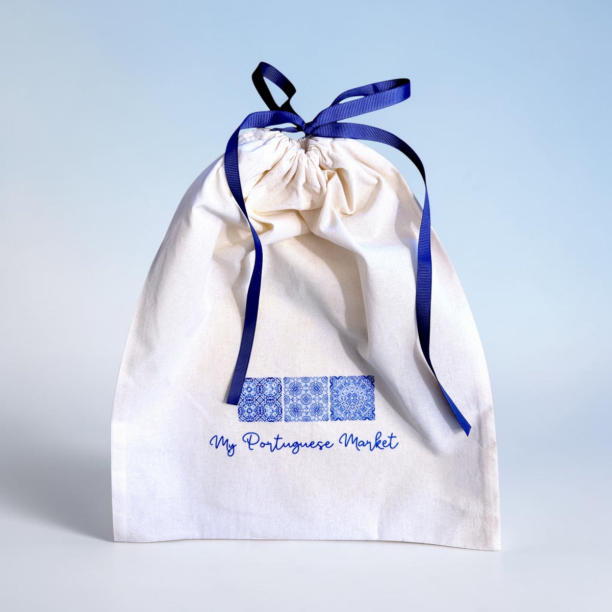 Cream My Portuguese Market gift bag with blue tile-inspired logo and navy ribbon closure